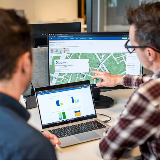 Fluvius medewerkers tonen de capaciteitswijzer op laptop.