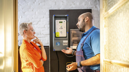 Technieker van Fluvius geeft uitleg aan een klant