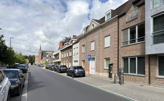Publieke laadpaal in woonstraat met geparkeerde elektrische wagen in Roeselare.