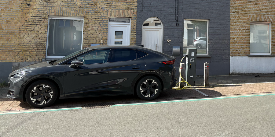 Publieke laadpaal in het straatbeeld van Roeselare met een elektrische wagen die aan het opladen is.