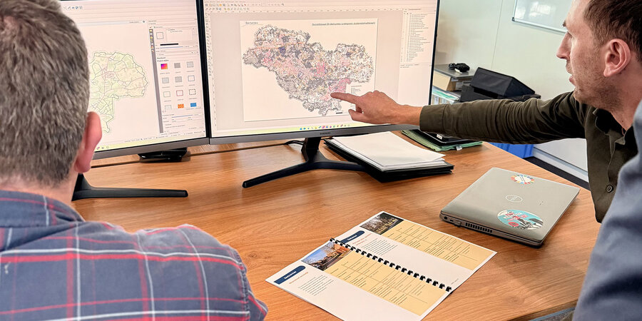 Masterplan openbare verlichting: tips uit Bonheiden Medewerkers analyseren een kaart van Bonheiden op computerschermen voor het opstellen van een masterplan voor openbare verlichting.
