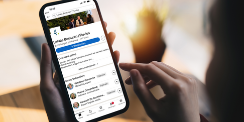 Smartphone toont LinkedIn-groep van Fluvius voor lokale besturen.